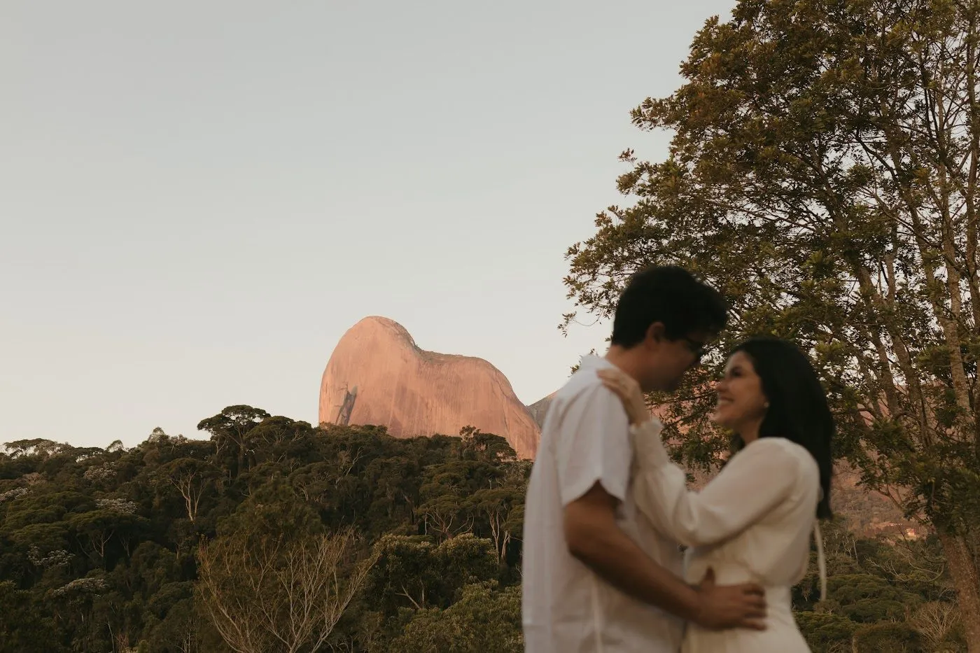 Natália e Douglas abraçados com a Pedra Azul ao fundo